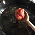 adding the tomato sauce to the deglazed skillet.