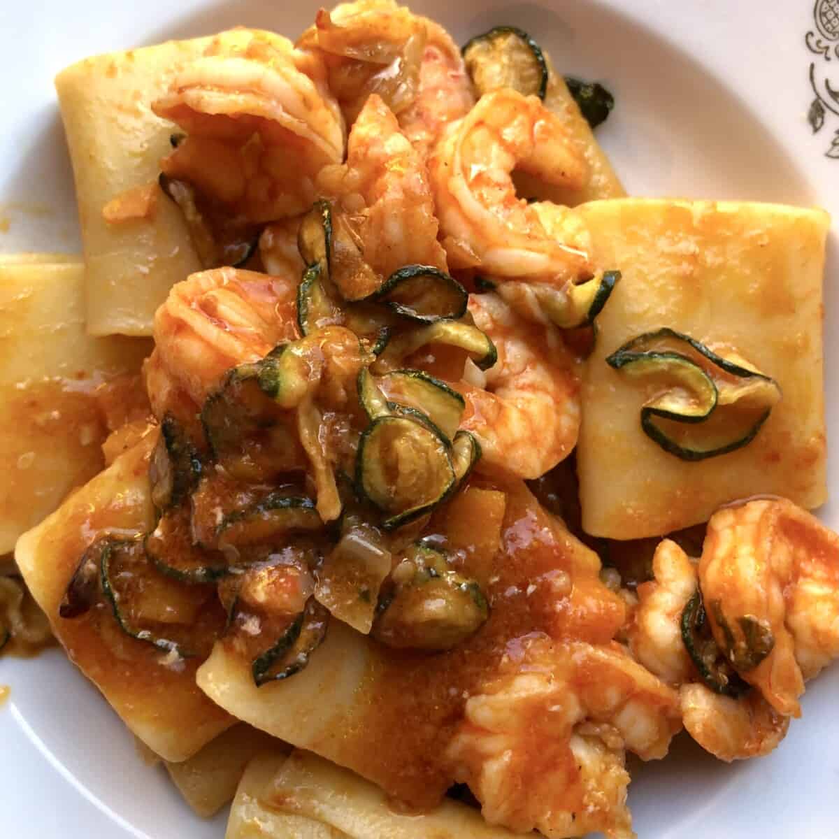 Pasta bowl filled with easy paccheri pasta with shrimp and zucchini in white wine tomato sauce.