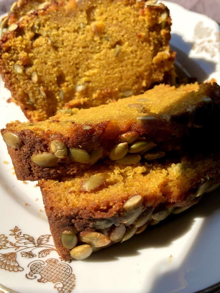 Super moist sliced pumpkin bread with toasted pumpkin seeds on top.