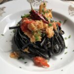 Squid Ink Linguine with Crab pasta in a pasta bowl with crab and tomatoes wine sauce.