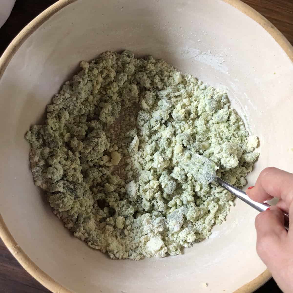 Spinach gnocchi ingredients combined using a fork and ready to form into a log, easy gnocchi recipe with spinach and potato.