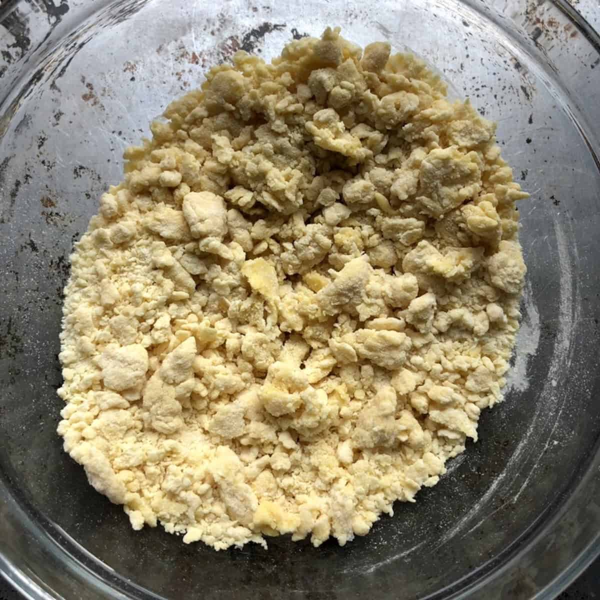 Shaggy chitarra pasta dough mixture ready to form into a ball, pasta alla chitarra from scratch.
