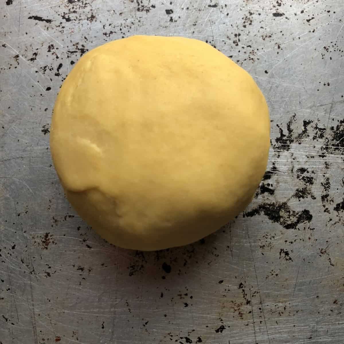 
Smooth rested chitarra semolina egg pasta dough ready to portion and roll, alla chitarra dough after resting.

