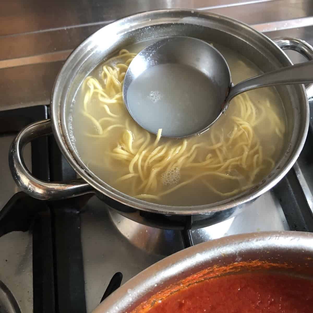 Homemade pasta chitarra cooking in salted boiling water until al dente, chitarra pasta recipe cooking step.