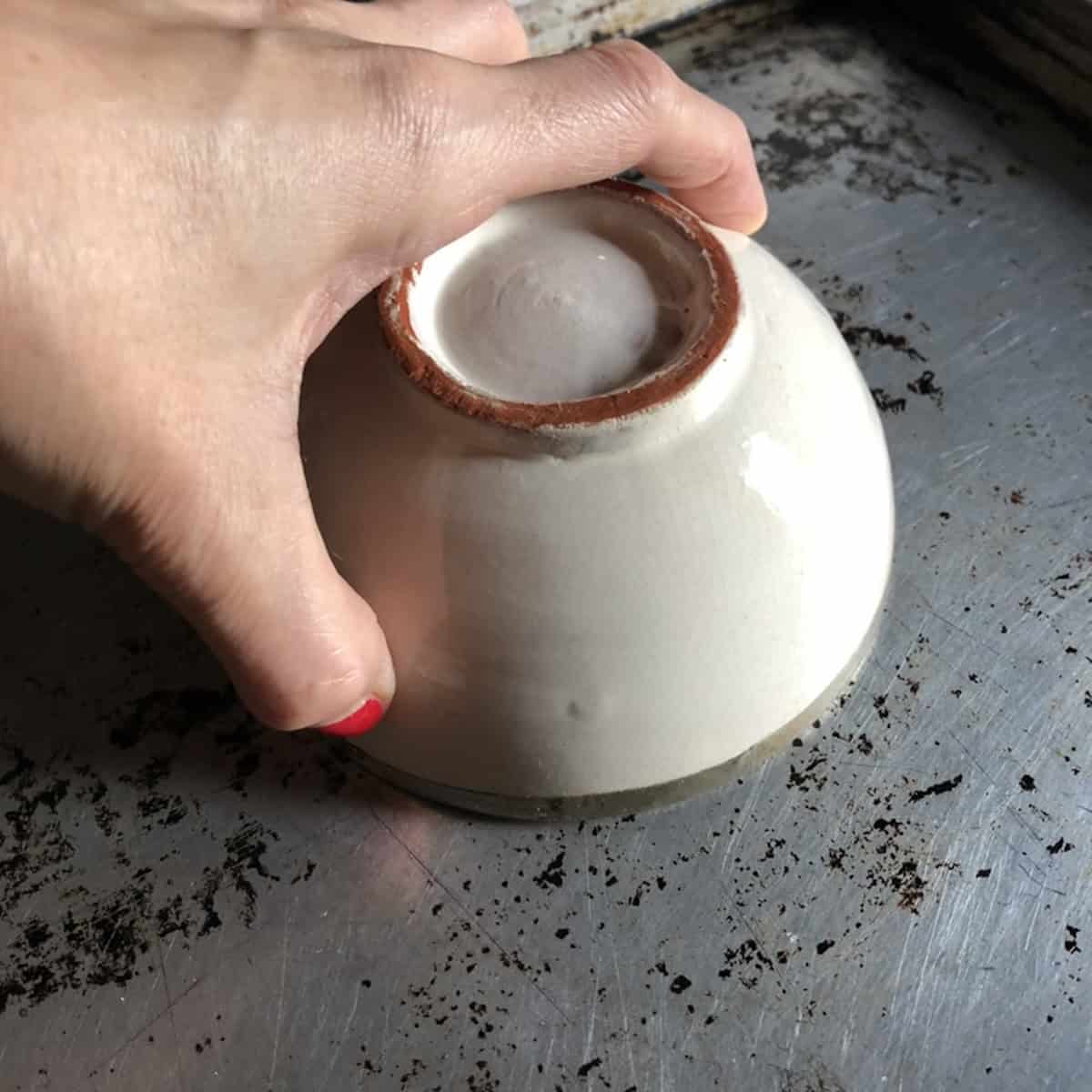 A ceramic bowl placed over the chitarra pasta dough ball to rest and relax the gluten before rolling.
