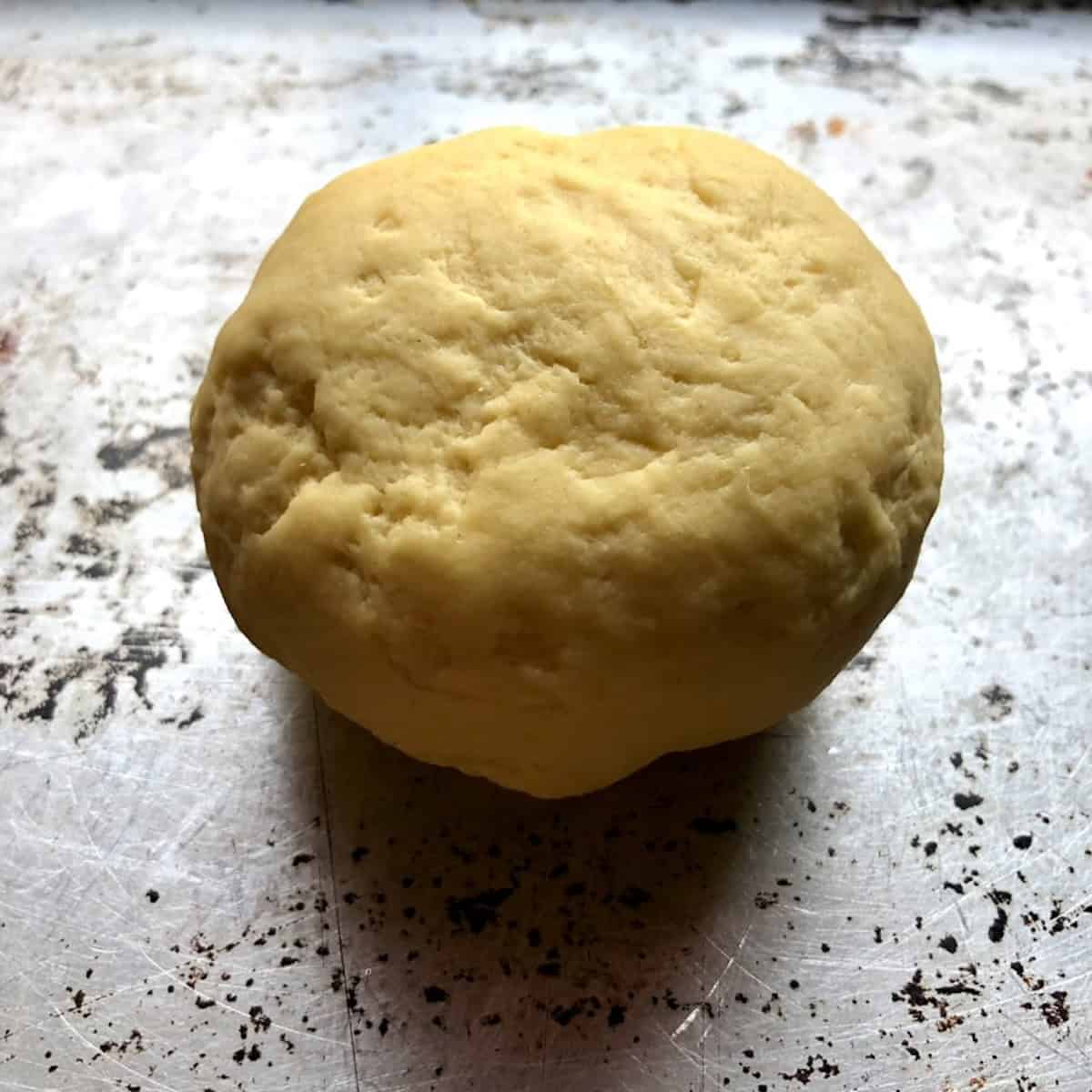 A ball of spaghetti alla chitarra dough just formed and ready to knead and looking rough.