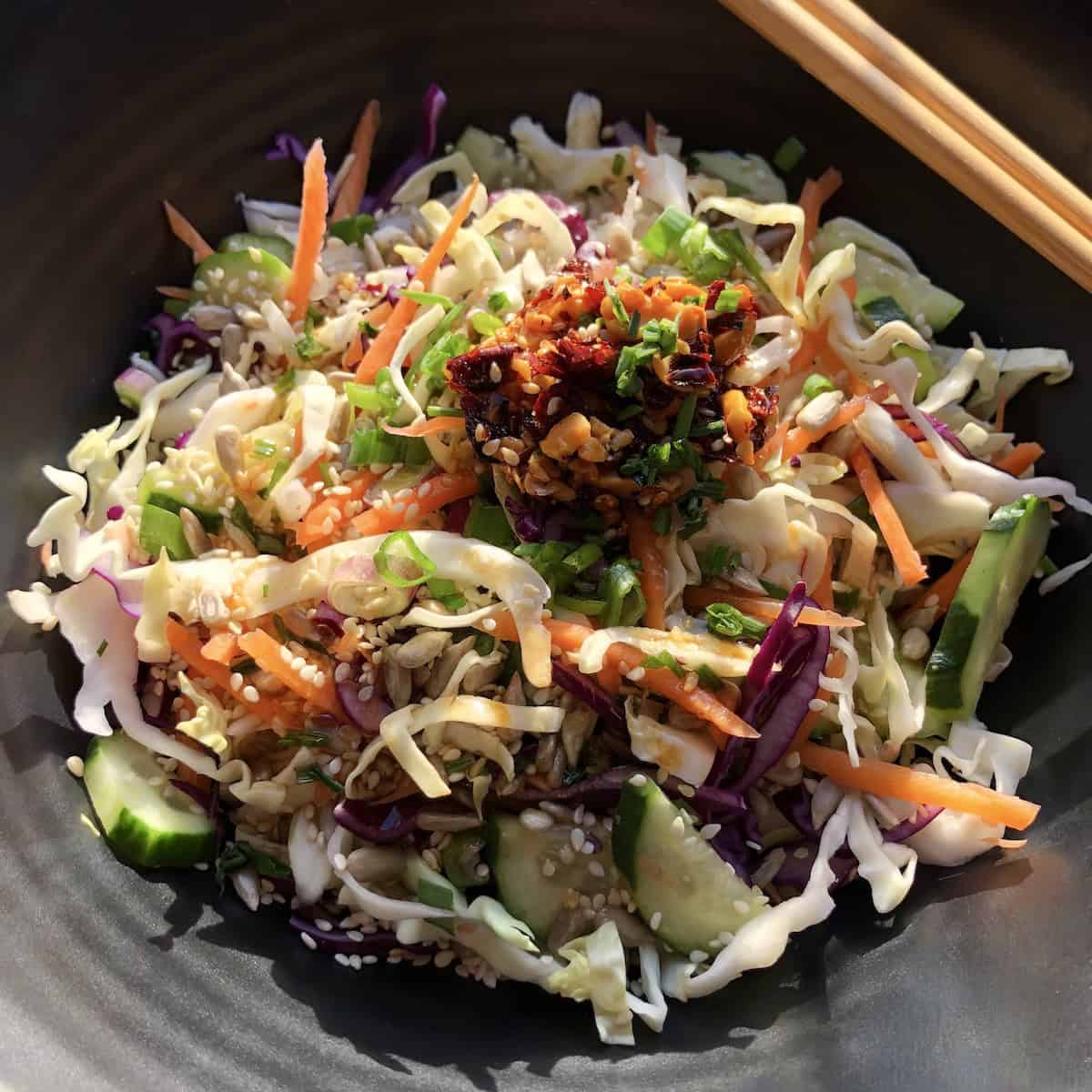 Asian chopped salad in a deep ramen bowl with chopsticks on the side.