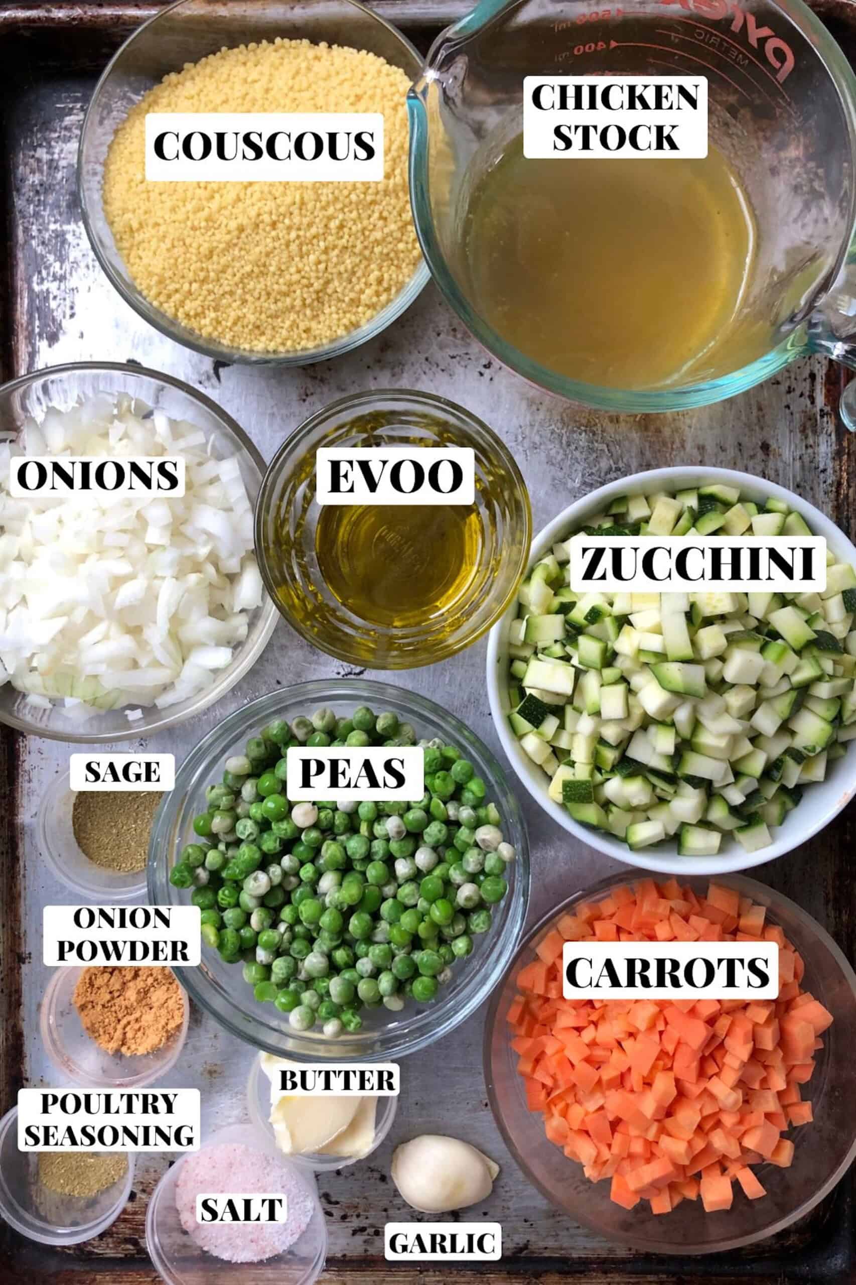 Authentic Italian Mediterranean couscous recipe ingredients measured in prep bowls including extra virgin olive oil, garlic, butter, onion powder, sage, poultry seasoning, diced zucchini, onions, carrots, peas, couscous and chicken stock for an easy homemade vegetable couscous.