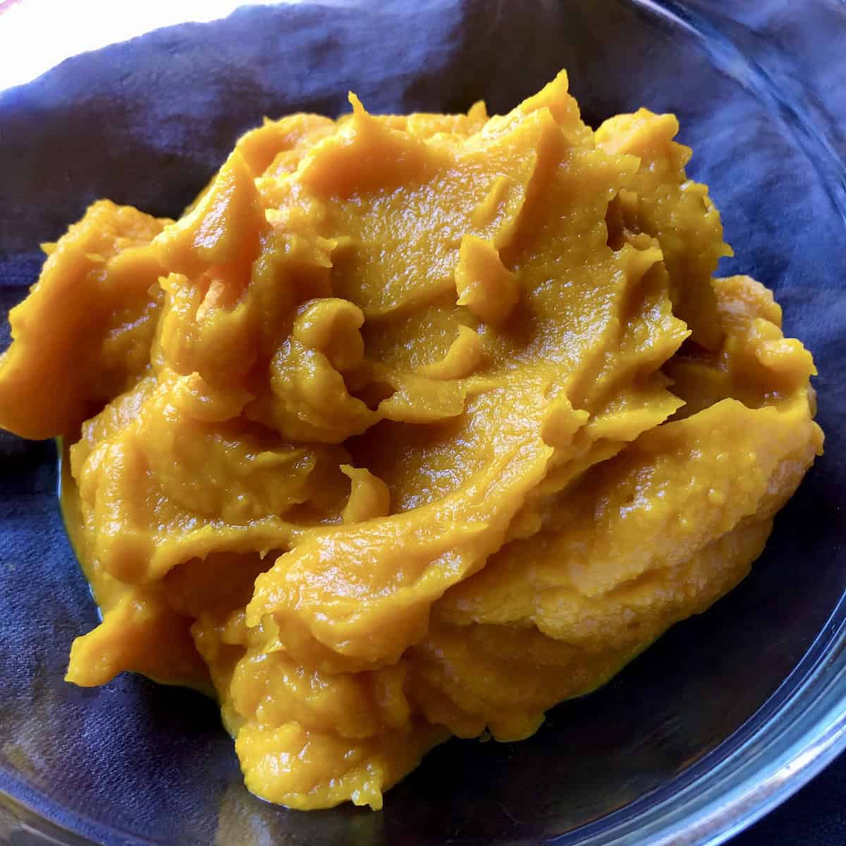 Homemade pumpkin puree in bowl, fresh pumpkin recipe for pasta dough and for adding to alfredo sauce to make a creamy pumpkin pasta.
