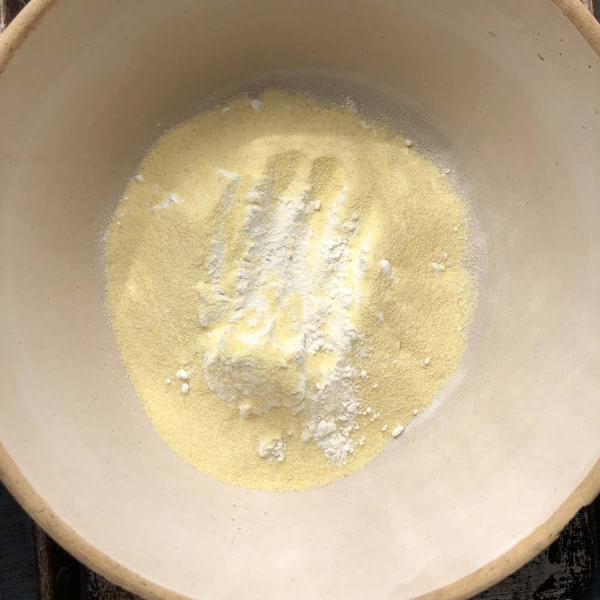 Pumpkin pasta dough flours showing semolina and 00 flour in bowl for step 1. of making homemade pumpkin pasta.