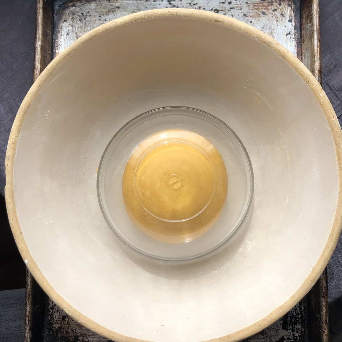 Fresh pumpkin pasta dough resting under glass bowl to relax before rolling for homemade pasta recipe.
