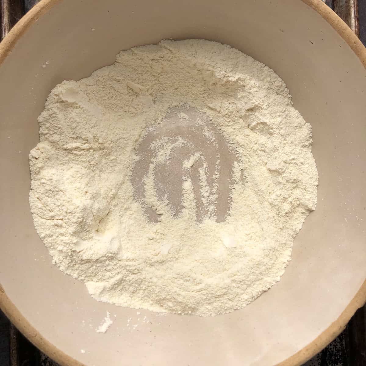 A well made in the middle of the flour mixture to add the eggs, canned pumpkin, and EVOO. 