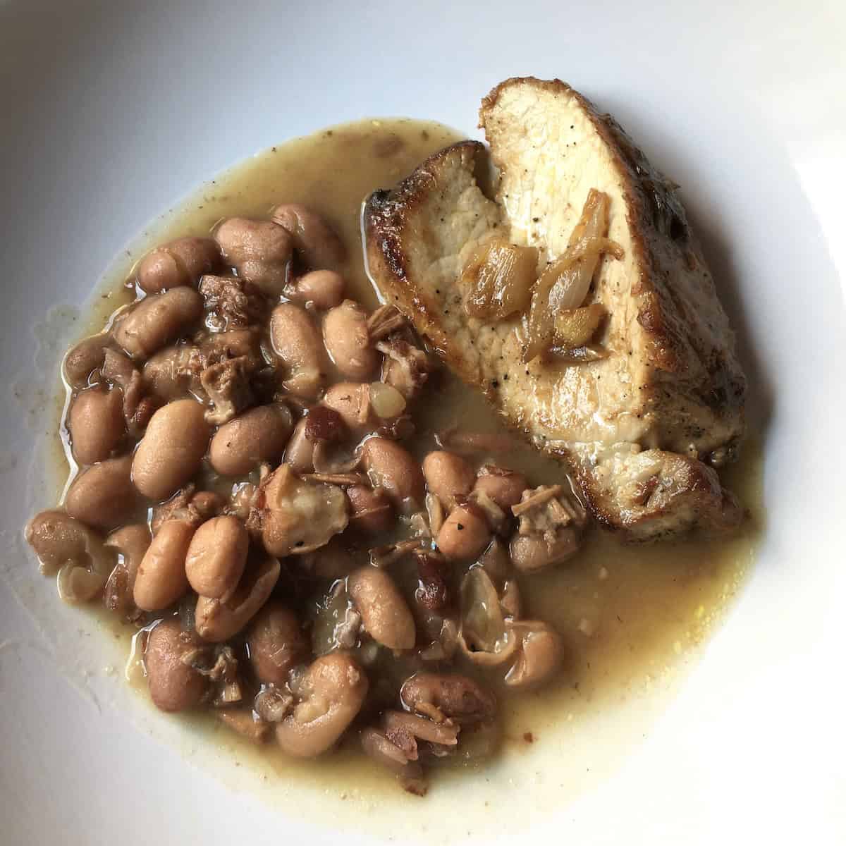 Homemade beans and ham with triple pork made using homemade chicken broth for rich flavor showing recipes with chicken broth.