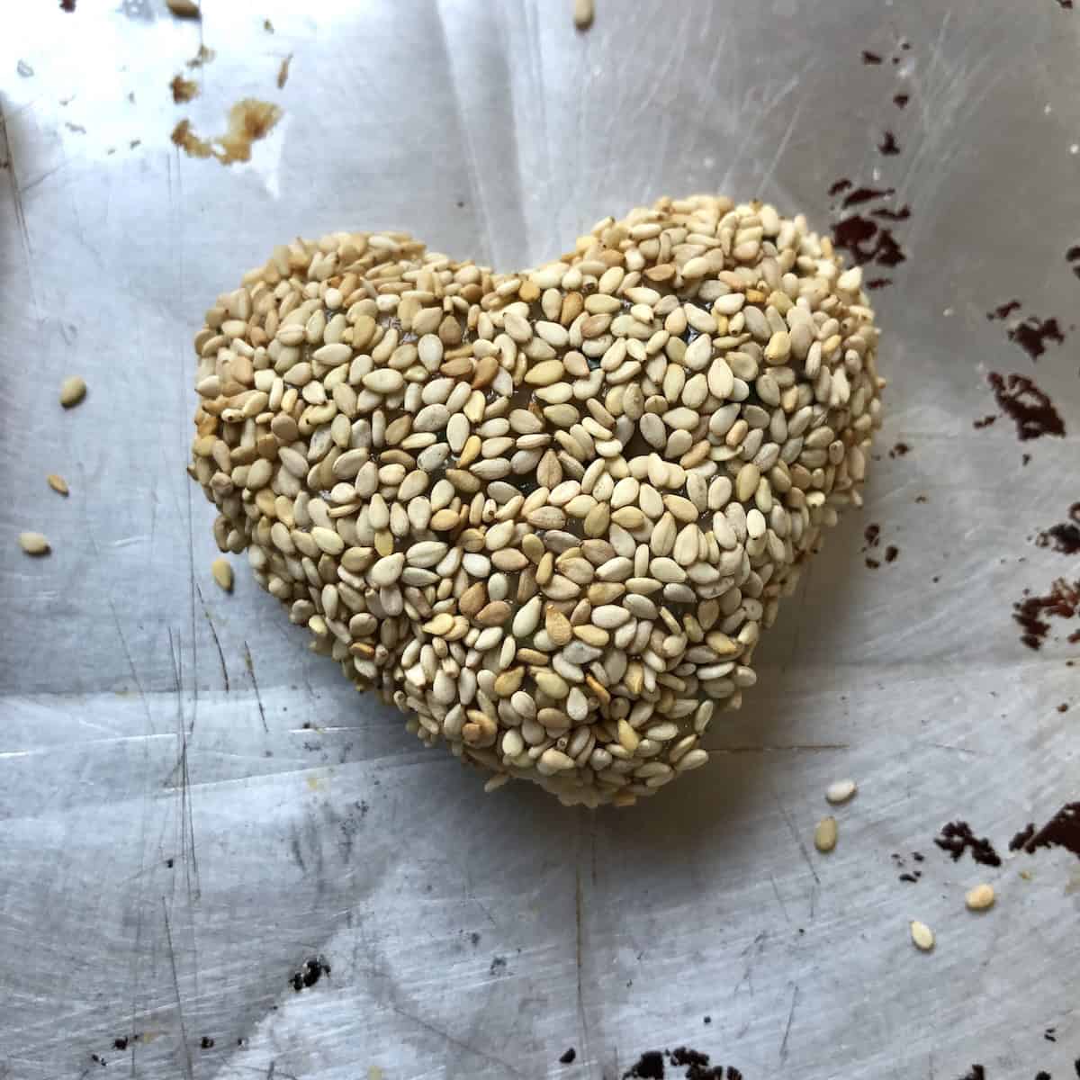 Heart shaped Chinese shrimp toast with sesame seeds fully assembled before frying for Valentine's Day prawn toast appetizer.