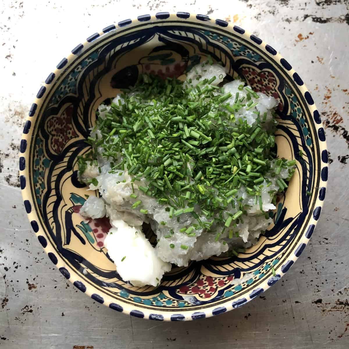 Leaf lard and sliced chives added to shrimp mixture in bowl for authentic homemade shrimp toast with pork fat.
