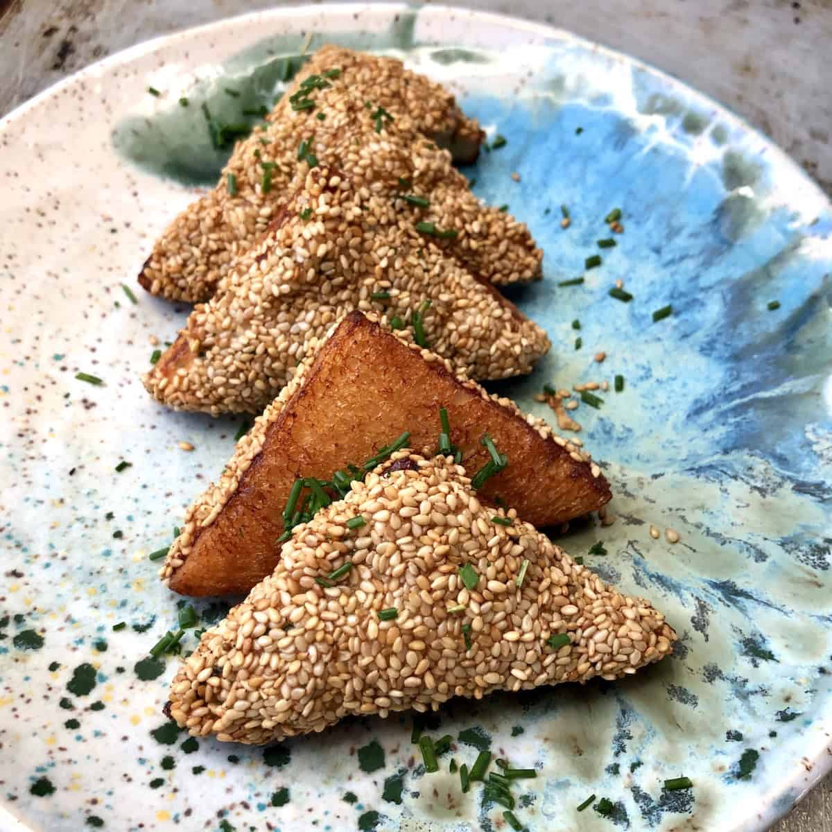Crispy golden brown homemade shrimp toast on a plate, a traditional Chinese appetizer with sesame seeds showing how to make shrimp toast for an authentic dim sum recipe.