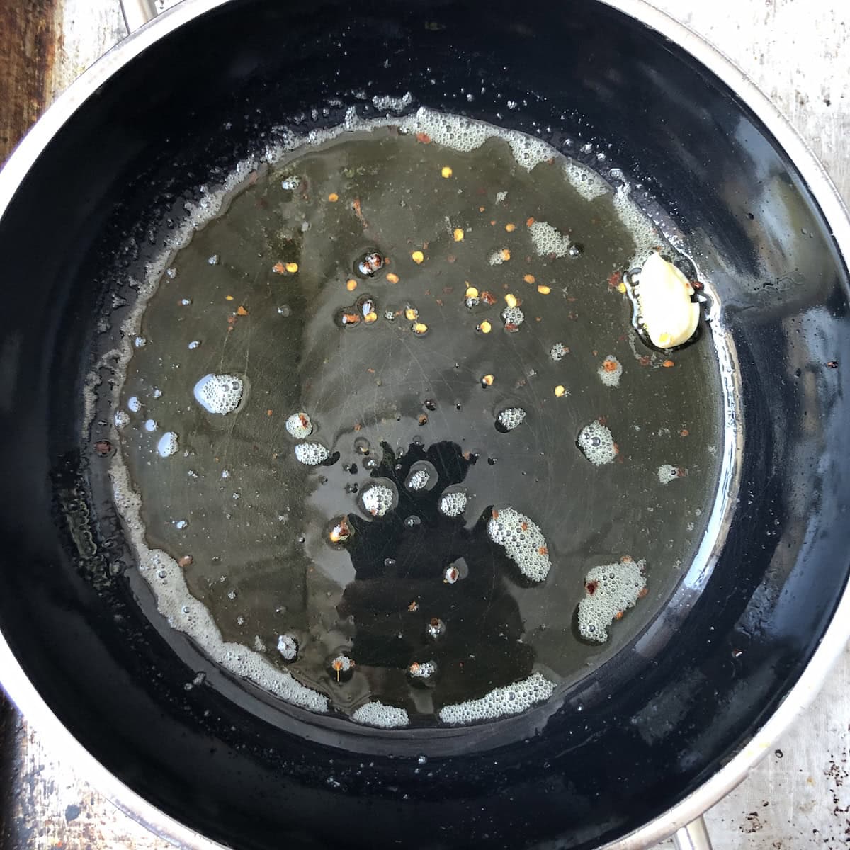 Blistering garlic in olive oil and clarified butter mixture with crushed red pepper flakes to start lobster ravioli tomato cream sauce.
