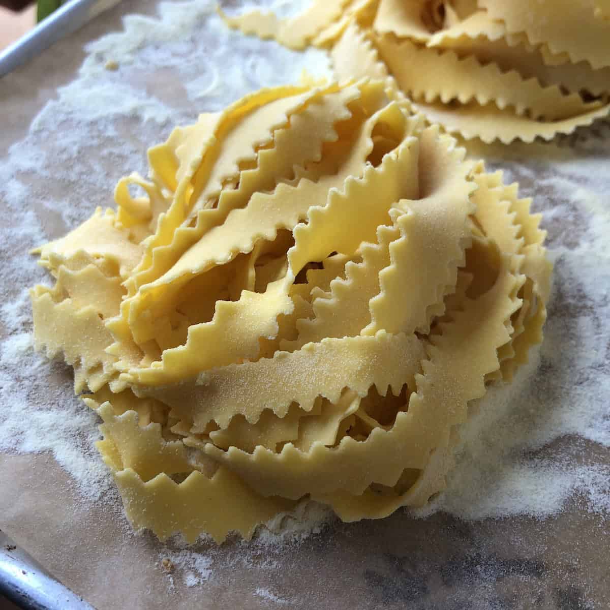 Fresh homemade egg pasta nests in reginelle shape with zigzag edges for classic Italian pasta ai funghi recipe.