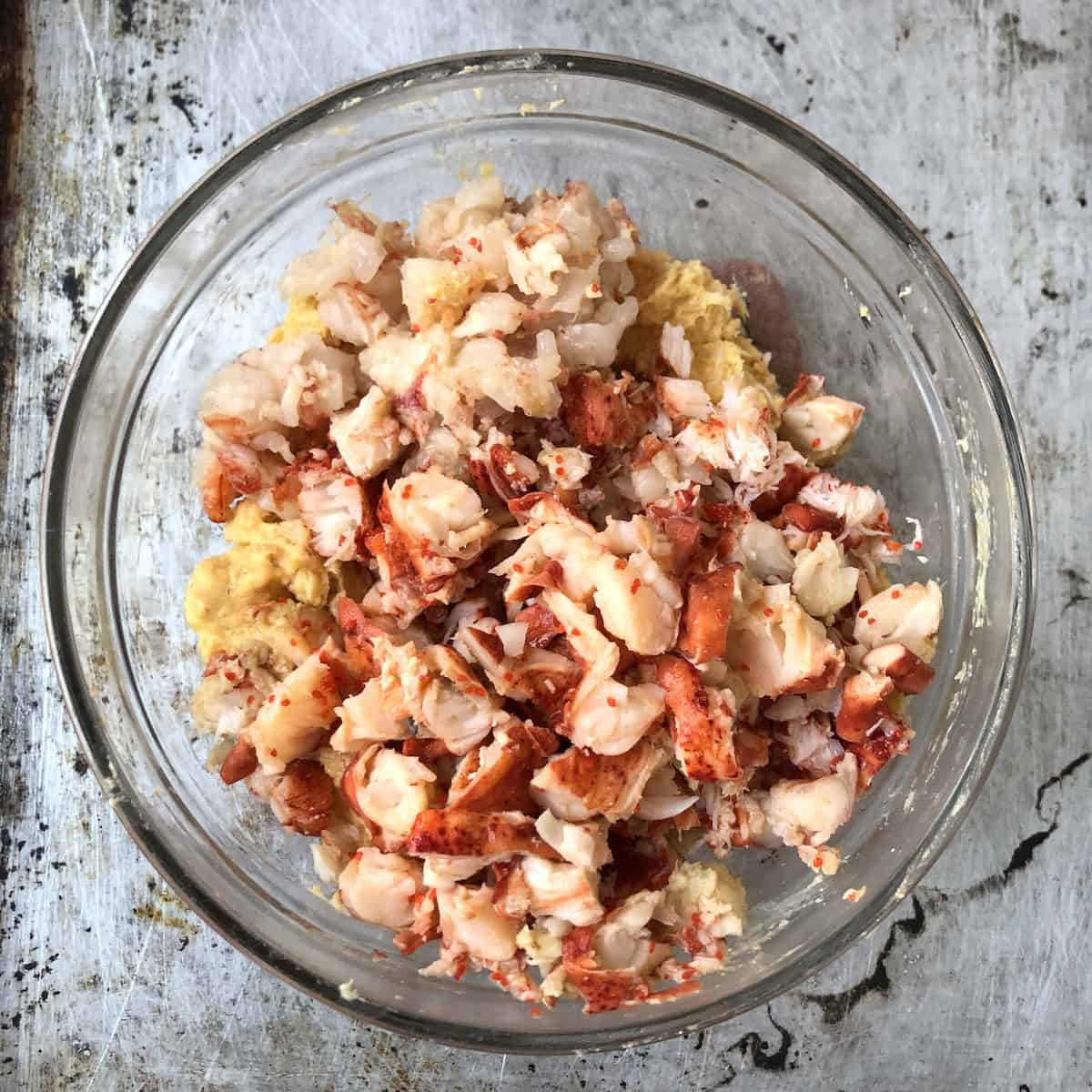 Diced lobster and shrimp added to mixing bowl with shrimp mousse before combining for homemade lobster ravioli filling.