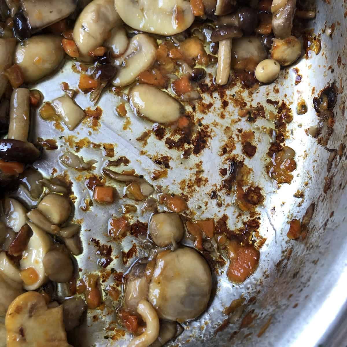 Sautéed mushrooms with fond on the bottom of the pan ready to deglaze with white wine for mushroom pasta sauce recipe.
