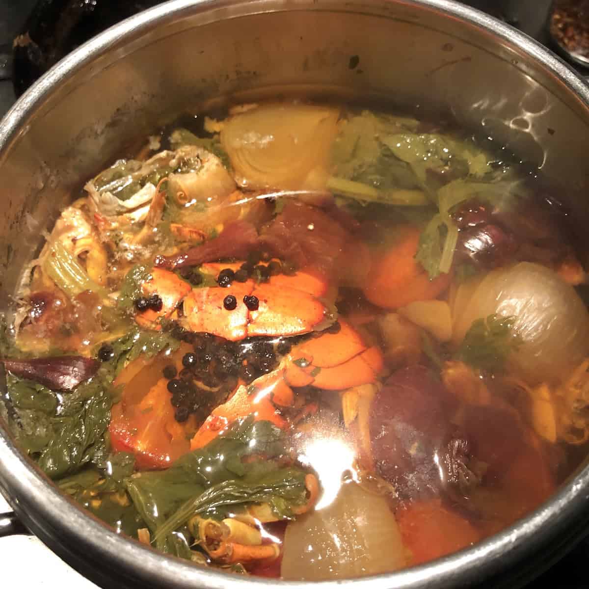 Finished homemade seafood stock made from lobster and shrimp shells ready to cook lobster ravioli, lobster bisque, seafood chowders, gumbos, or homeade shrimp and lobster tortellini in brodo.