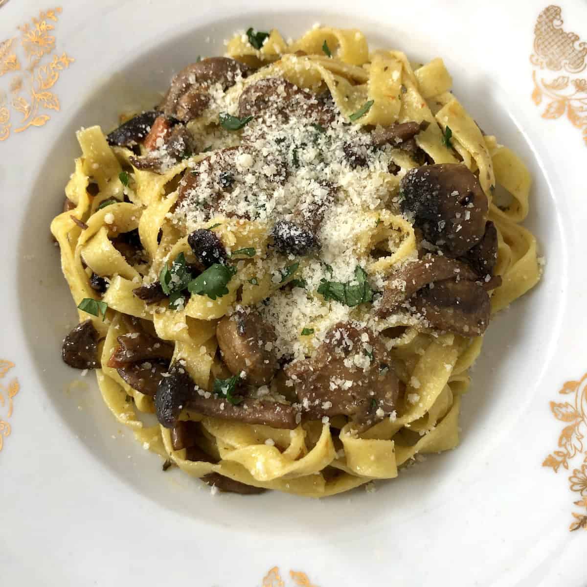 Top down view of easy tagliatelle mushroom pasta with caramelized carrots, parsley, and Grana Padano, a healthy garlic mushroom pasta dish made without cream.