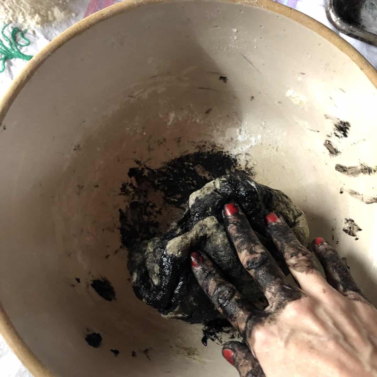 My hand covered in black squid ink trying to incorporate more ink into the dough because I didn't add enough to begin with (it looks like a hot mess, but it all washes off without a problem).
