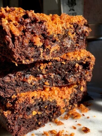 Stack of three gooey fudgy Biscoff brownies with Biscoff spread swirl and crunchy cornflake layers, the best homemade brownie recipe with cookie butter.