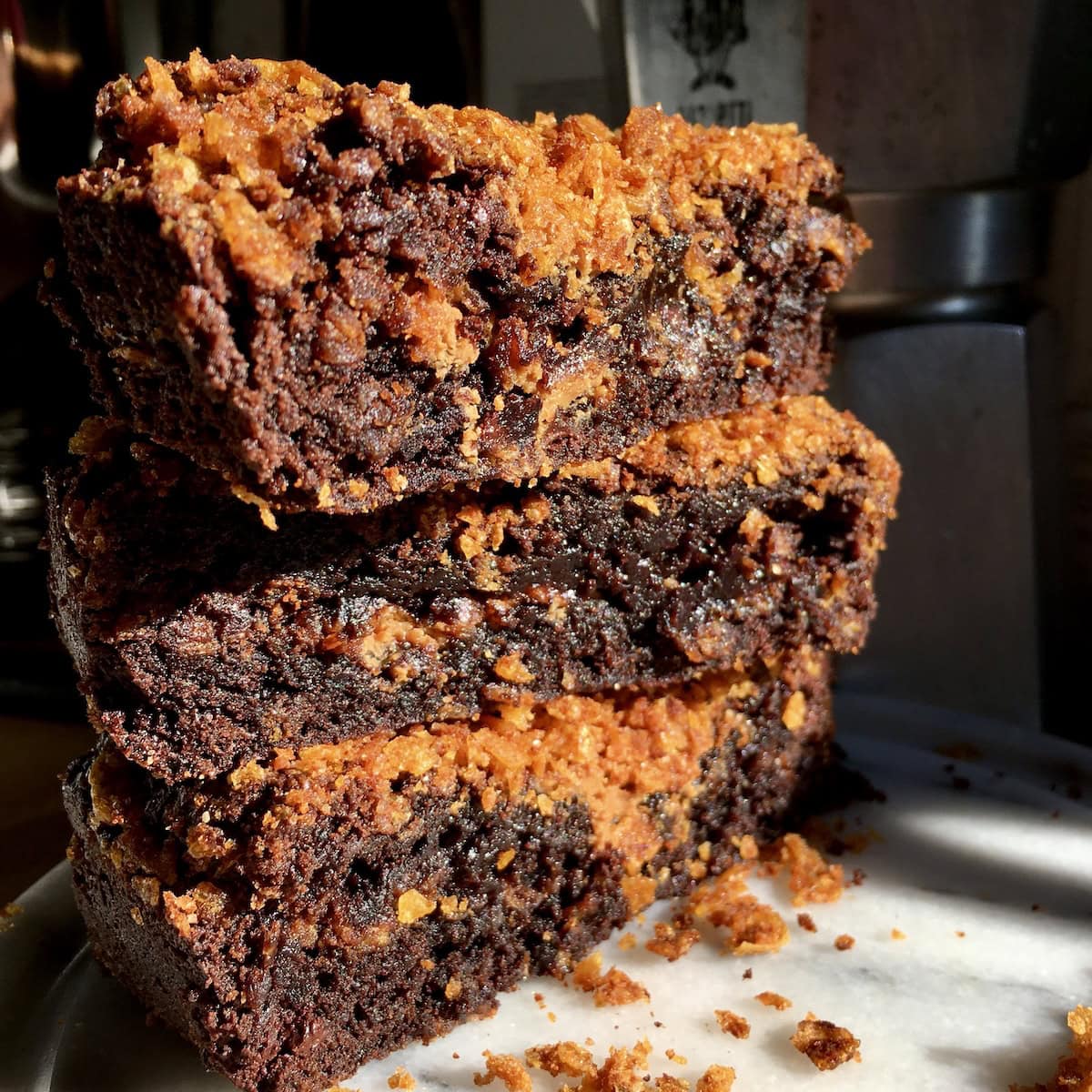 Stack of three gooey fudgy Biscoff brownies with Biscoff spread swirl and crunchy cornflake layers, the best homemade brownie recipe with cookie butter.