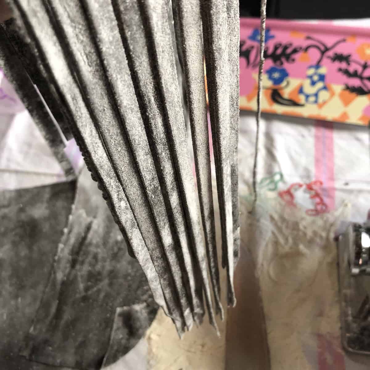 Black fettuccine cut with Marcato Atlas pasta machine showing fresh squid ink noodles for homemade cuttlefish ink pasta.
