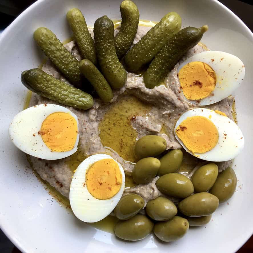 Creamy black-eyed pea hummus drizzled with extra virgin olive oil in the center well, served with halved hard boiled eggs, pickles, and green olives. A protein-packed meatless lenten dip or light meal.