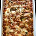 Whole eggplant and zucchini parmigiana fresh from the oven in a baking dish with golden melted cheese and bubbly tomato sauce. Food52 and Pinterest Golden Recipe grand prize winner and an impressive meatless lenten family dinner.