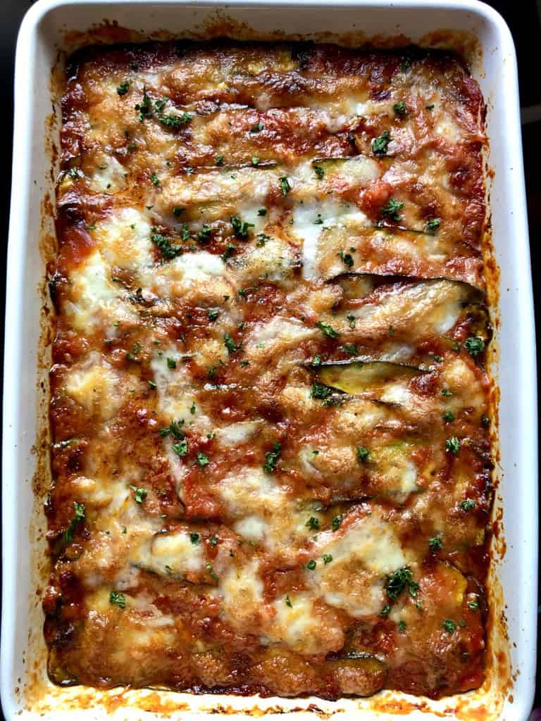 Whole eggplant and zucchini parmigiana fresh from the oven in a baking dish with golden melted cheese and bubbly tomato sauce. Food52 and Pinterest Golden Recipe grand prize winner and an impressive meatless lenten family dinner.