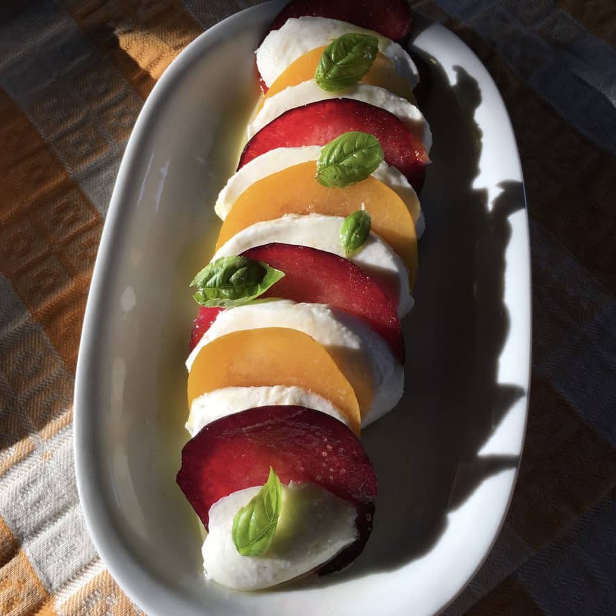 A beautiful plum caprese salad with thick slices of buffalo mozzarella, purple rose-hued plums, and golden orange plum slices drizzled with extra virgin olive oil and sprinkled with Maldon sea salt for a unique twist on classic caprese salad. A stunning meatless lenten salad.