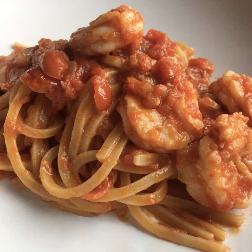 Naturally creamy triple shrimp pasta made without cream, featuring trighetto pasta in a rich tomato shrimp sauce that uses all parts of the shrimp including the heads to flavor the pasta in a deep pasta bowl. A decadent lenten seafood pasta recipe.