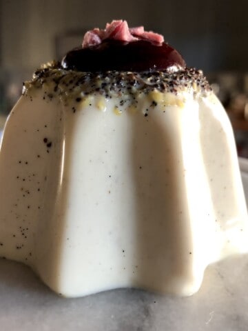 Authentic Italian vanilla bean panna cotta in pandoro star shape with wild berry coulis sauce and chopped strawberries with white chocolate, classic Italian panna cotta recipe easy no bake dessert.