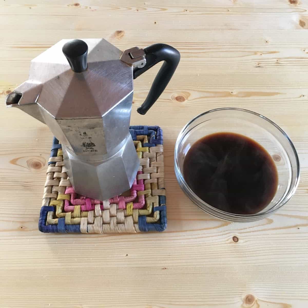 Bialetti 9-cup moka pot next to a bowl of freshly brewed espresso for making Italian tiramisu.