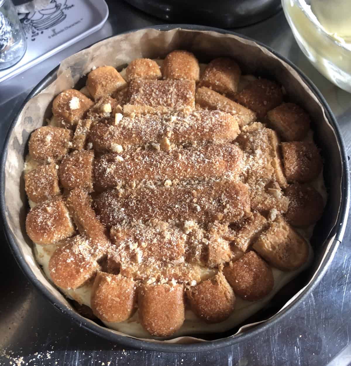 Top final layer of espresso soaked ladyfingers added over the mascarpone cream for tiramisu cake.