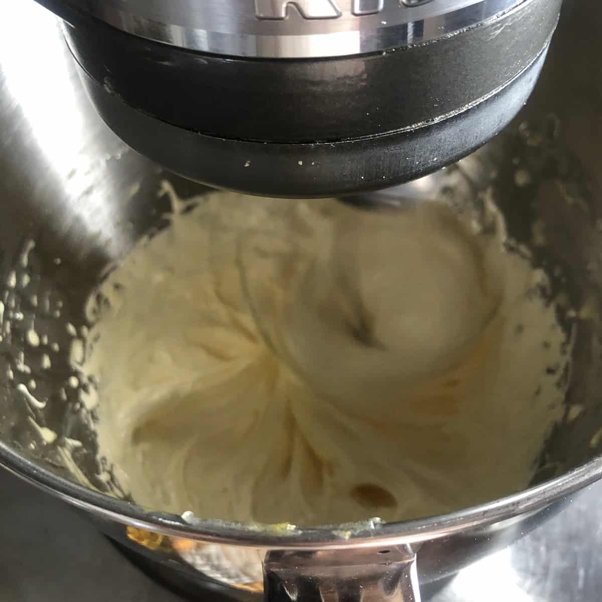 Pale yellow thick egg yolks whipped to ribbon stage in stand mixer for tiramisu cream ready for the sugar syrup to be added for pasteurization using the pate à bombe method.