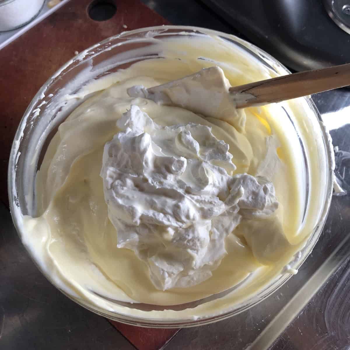 Folding whipped heavy cream into the mascarpone tiramisu cream for the perfect texture.