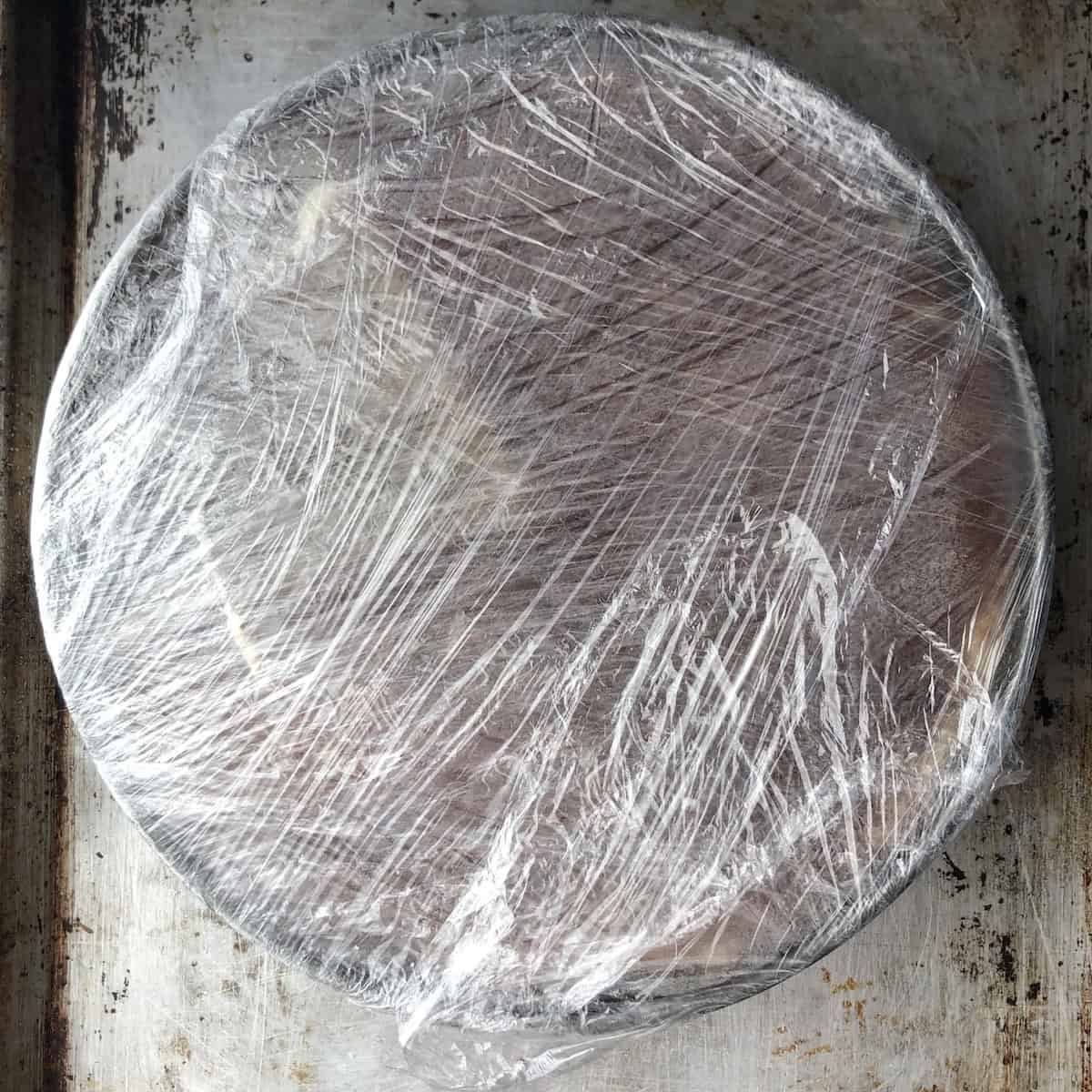 Whole assembled tiramisu wrapped and ready to refrigerate overnight to set in the springform pan.
