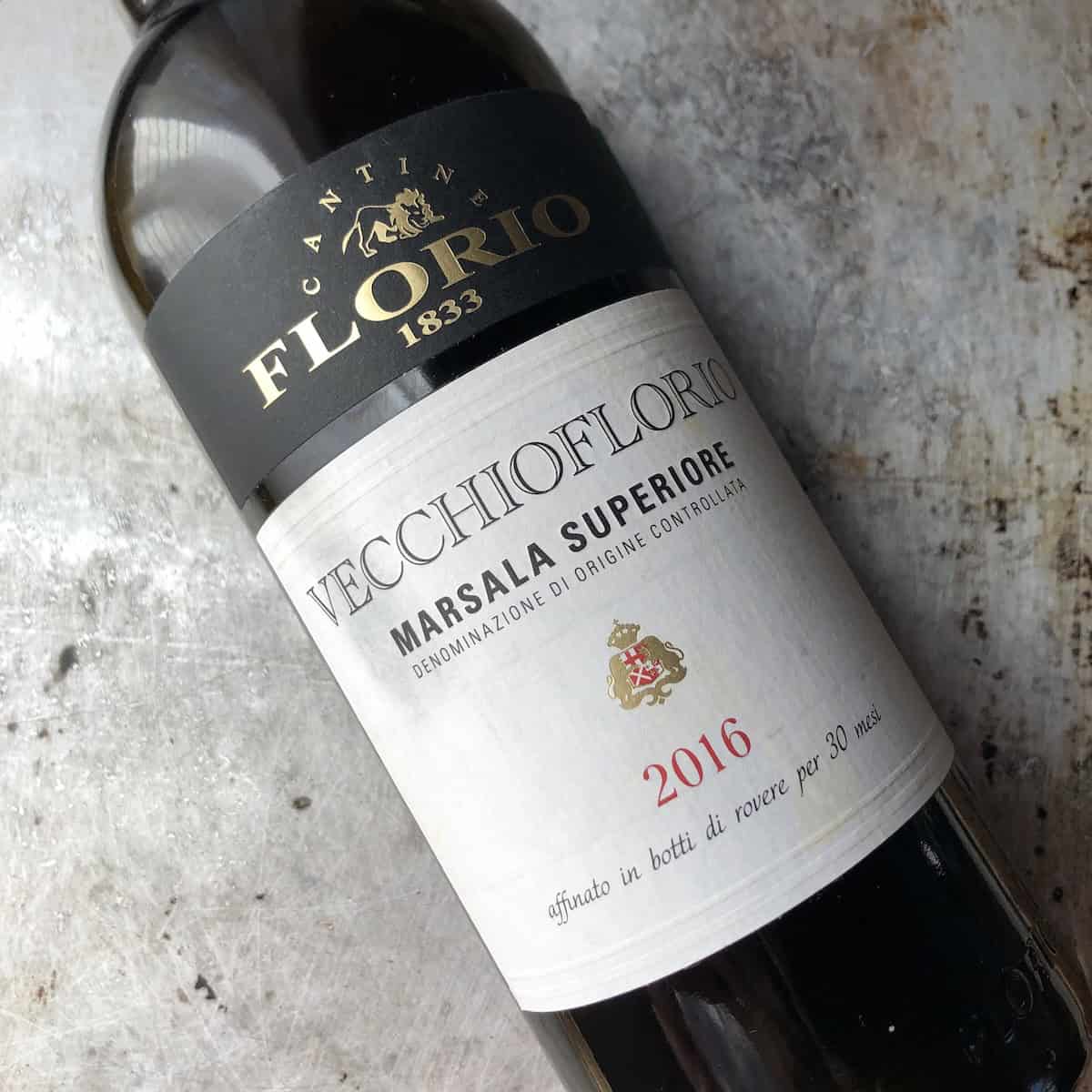 Bottle of Cantina Florio 1833 Vecchioflorio Marsala Superiore DOC 2016 aged 30 months on a baking tray, dry (secco) marsala wine for traditional tiramisu.