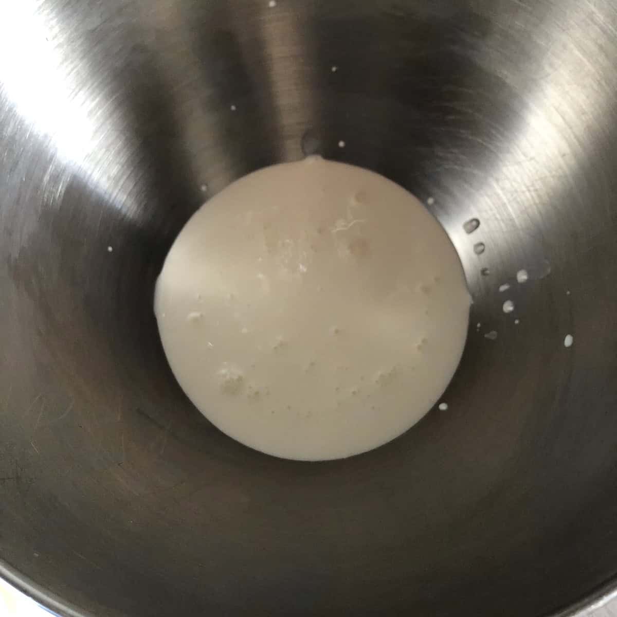 Cold heavy cream in a clean KitchenAid mixing bowl ready to be whipped to stiff peaks for tiramisu.
