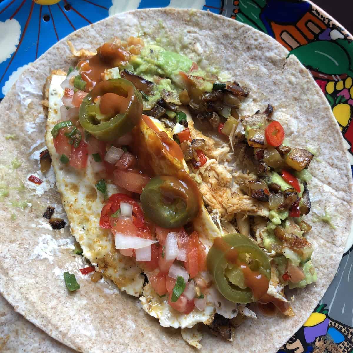 Breakfast burrito with eggs, chicken, and guacamole.
