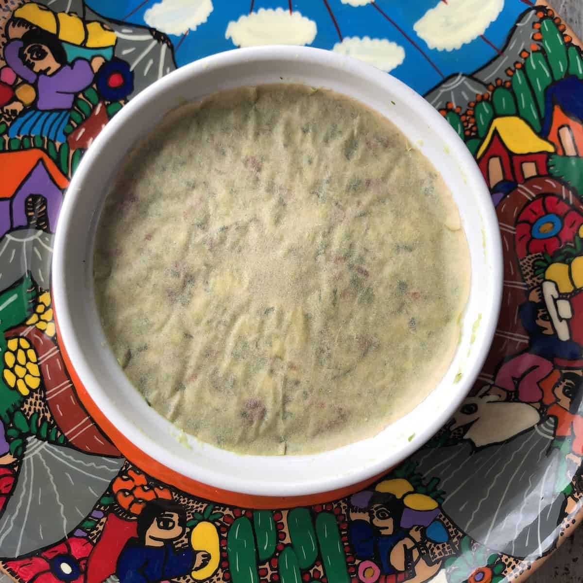 Parchment paper cut to fit exactly over the top of guacamole with no gaps or air pockets to prevent browning.
