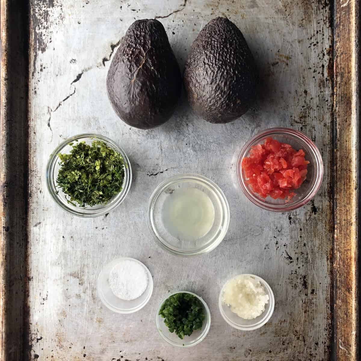 Mise en place of guacamole ingredients all prepped and ready to start making fresh guacamole.
