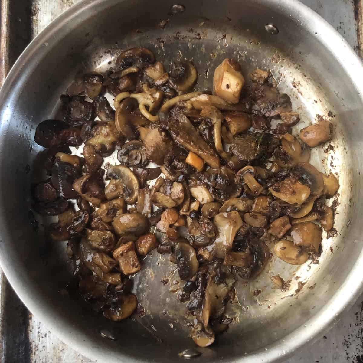 Glossy porcini and wild mushrooms after deglazing with the fond fully picked up from the pan, simple mushroom risotto technique for a rich and flavorful risotto mushroom base.
