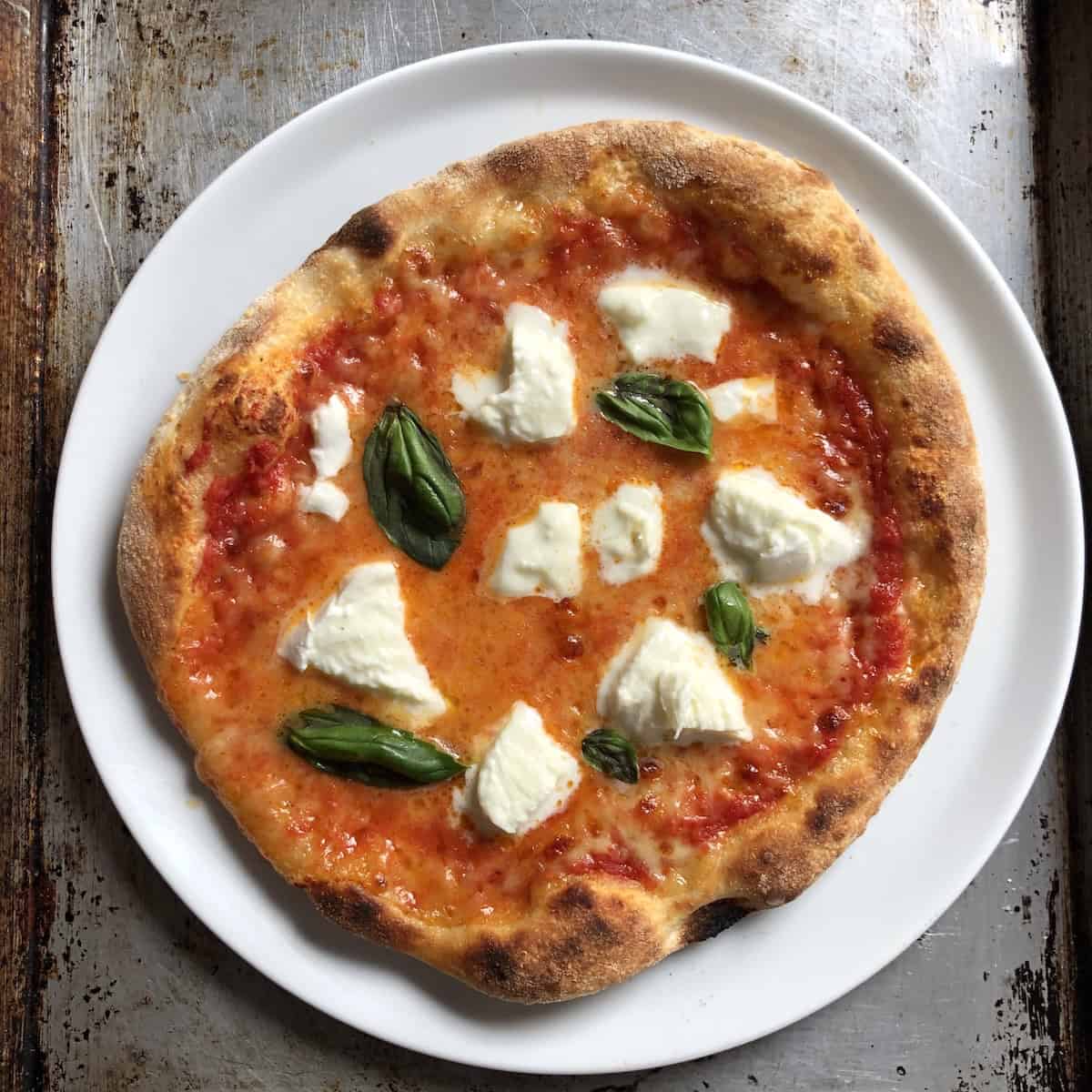 Homemade pizza margherita con bufala made with Caputo Nuvola 00 flour for a light and airy thick crust pizza dough, margherita pizza recipe with buffalo mozzarella on a fluffy pizza crust.
