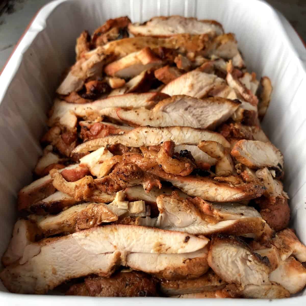 Sliced pollo asado chicken ready to cover and store, chicken asado recipe meal prep for easy reheating.
