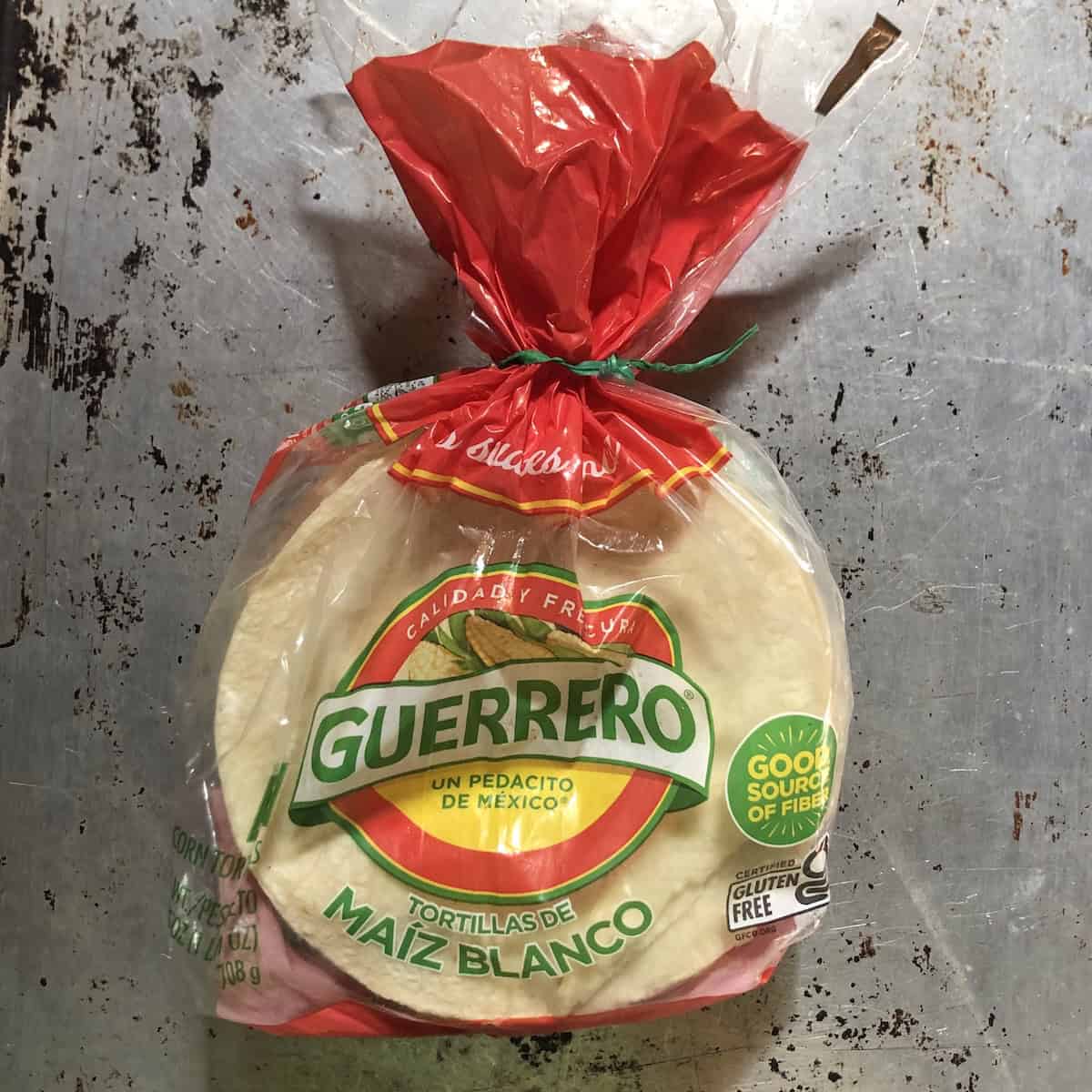 A package of 30 count Guerrero white corn tortillas on a baking sheet pan for tacos, taquitos, enchiladas, or fresh fried tortilla chips.
